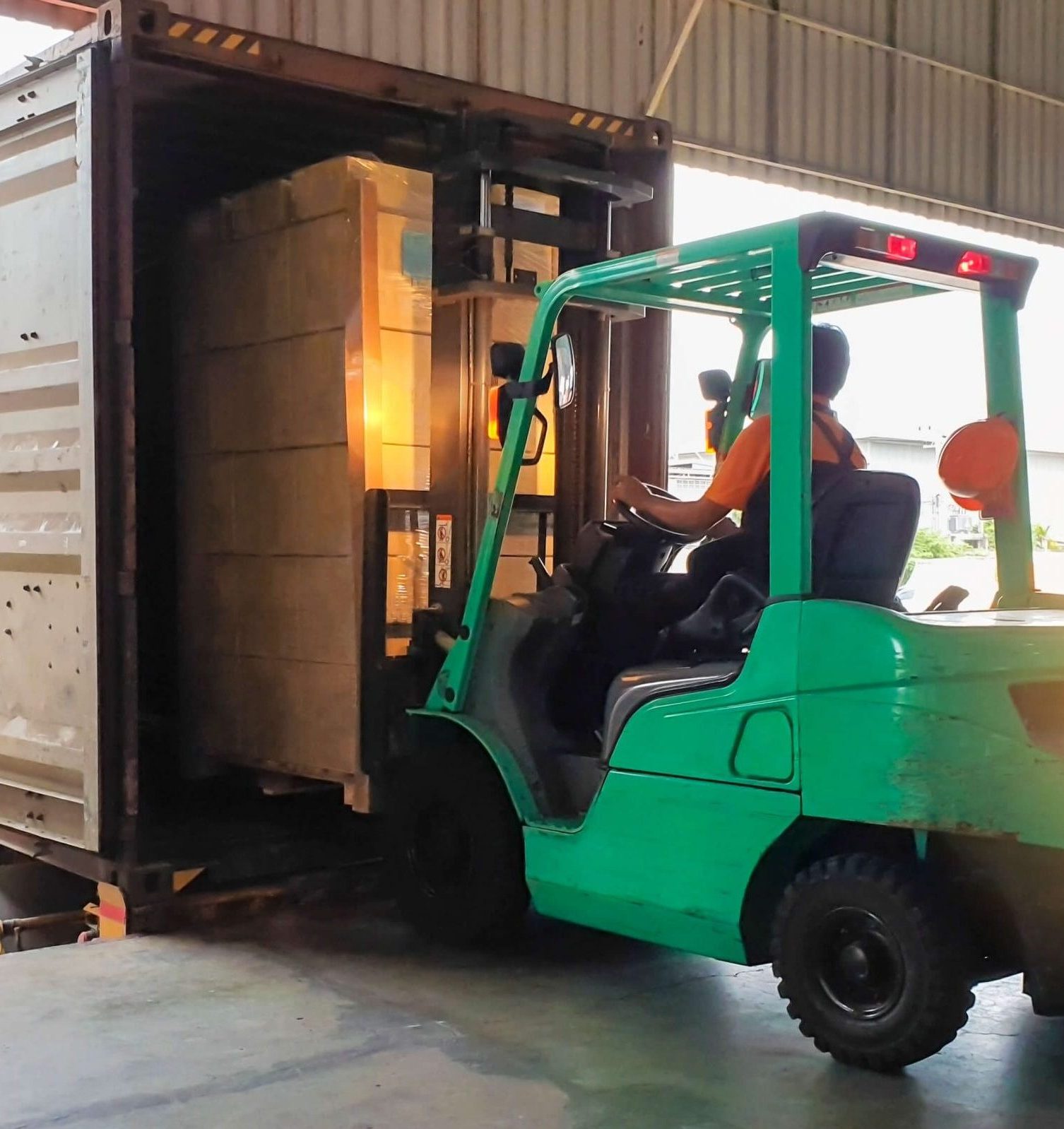 Forklift carrying pallets of fruit into a truck